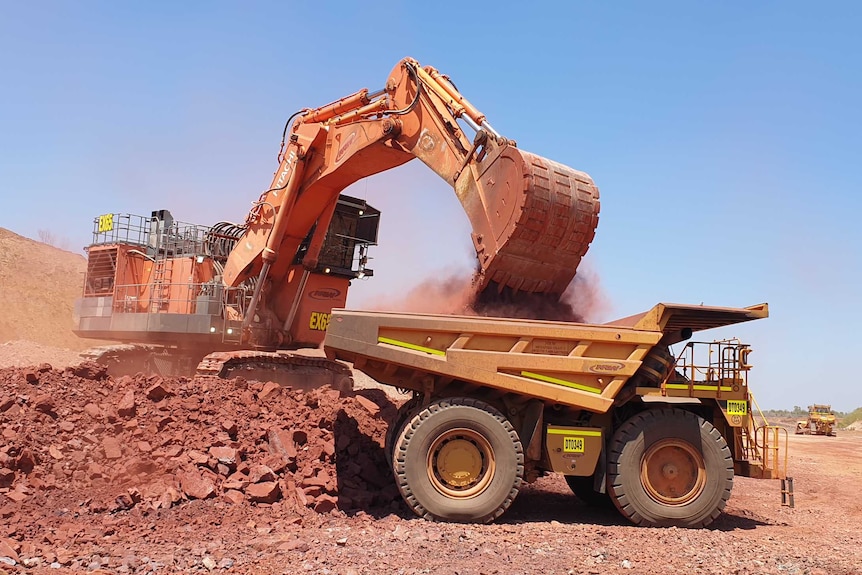 Một thợ đào đang chất đầy quặng sắt vào một chiếc xe tải ở NT.